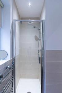 um chuveiro com uma porta de vidro na casa de banho em Kelvin Grove by UStay em Liverpool
