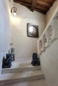 a stairway with a clock on the wall at Le Clos des Consuls in Tarascon