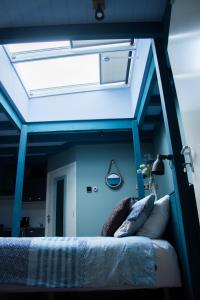 Cama en habitación con techo azul en B&B de Ster van Dwingeloo en Dwingeloo