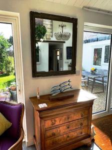 un tocador de madera con un espejo encima en Cybil's Retreat - Renovated 2 bedroom house with enclosed garden, en Uppingham
