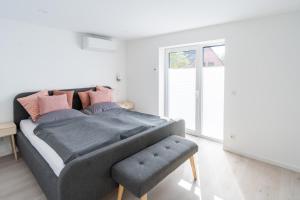 Dormitorio con cama con manta gris y taburete en Zur alten Bäckerei, 