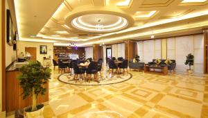un hall avec des tables et des chaises dans un bâtiment dans l'établissement لاريتشي جدة للشقق المخدومة, à Djeddah