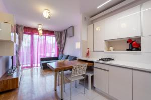 a kitchen and a living room with a table at Apartament Central Carol in Bucharest