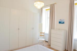 a bedroom with white cabinets and a chandelier at Apartment am Traunsee in Gmunden