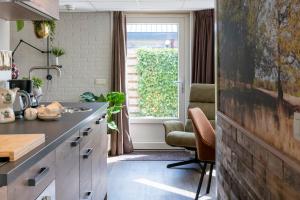 a kitchen with a counter and a window at B&B de Ster van Dwingeloo in Dwingeloo