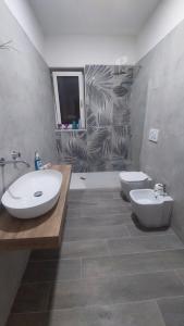 ein Badezimmer mit zwei Waschbecken, einem WC und einer Dusche in der Unterkunft La Perla in Castel San Giorgio