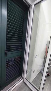 eine grüne Tür mit einem Fenster in einem Zimmer in der Unterkunft La Perla in Castel San Giorgio