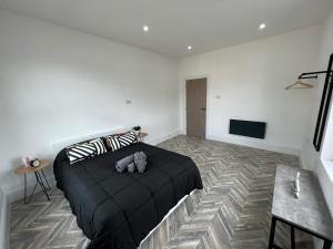 a bedroom with a bed with a stuffed animal on it at Sleek & Stylish Spacious Apartment near Leeds City Centre in Headingley