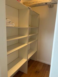 a walk in closet with white shelves and wood floors at Ausspanne Dassow in Dassow