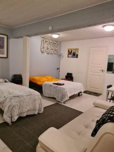 een slaapkamer met 2 bedden en een bank. bij Hostelli Karvia in Karvia