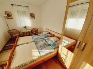 a bedroom with a bed and two chairs and a window at Hibiscus Nyaraló in Balatonfenyves
