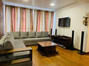 sala de estar con sofá y TV de pantalla plana en Lemas Holiday Bungalow, en Nuwara Eliya