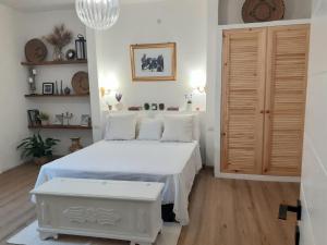 1 dormitorio con cama blanca y suelo de madera en Nuovissima Casa in Sardegna!!!!!!!, en Laerru