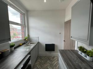 a kitchen with a sink and a window at Sleek & Stylish Spacious Apartment near Leeds City Centre in Headingley