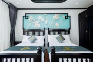 um quarto com duas camas e um quadro na parede em De Stefano Coffee and Hotel em Duong Dong