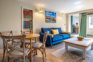 un salon avec un canapé bleu et une table dans l'établissement Spyglass Cottage by Big Skies Cottages, à Cley next the Sea 18 autres photos