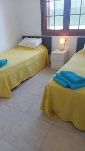 um quarto com duas camas com lençóis amarelos e um candeeiro em Casa Bello em Palomares