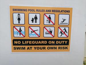 uma placa na parede que diz regras e regulamentos da piscina em Yes Muar em Muar