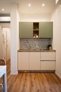 a kitchen with white cabinets and a wooden floor at Appartamento Garuda20 in Cavallino-Treporti +40 photos