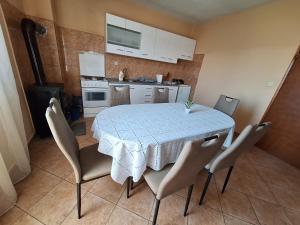 a kitchen with a table with chairs and a kitchen with white cabinets at Mara in Zadar