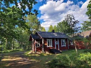 a small red house in the middle of a yard at Hästveda Vandrarhem och Stugor in Hästveda