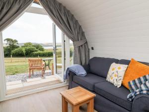 a living room with a couch and a large window at Ash in Saltash