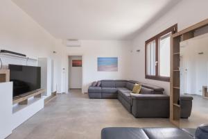 - un salon avec un canapé et une télévision dans l'établissement Villa Sirio by Perle di Puglia, à Veglie