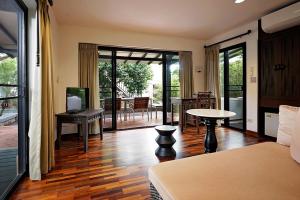 Habitación con cama, mesa y patio. en Praseban Resort, en Pran Buri