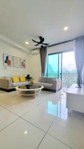 a living room with a couch and a ceiling fan at Lost World Of Tambun Coco Guest House in Ipoh