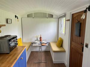 uma pequena cozinha com uma pequena mesa numa pequena casa em Shepherds Hut with Hot Tub em Wells