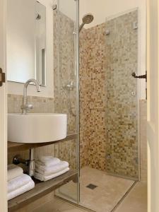 uma casa de banho com um lavatório e uma cabina de duche em vidro. em Trullo Vicino al Mare em Ostuni