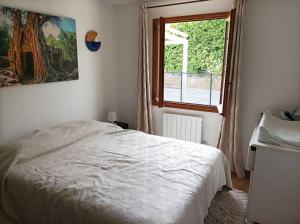 um quarto com uma cama branca e uma janela em Villa avec piscine privée proche Bandol/Beausset em Le Beausset