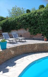 uma piscina com espreguiçadeiras ao lado de uma parede de tijolos em Villa avec piscine privée proche Bandol/Beausset em Le Beausset