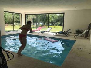 uma mulher de biquíni parada numa piscina em Maison campagne/Lac, 8 personnes em Saint-Quentin-sur-Charente