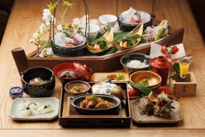 uma mesa com muitos tipos diferentes de alimentos sobre ele em Ryokan Masuya em Ōda