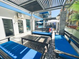 a patio with two blue benches on a building at Traumhaftes Apartment mit Privatstrand, Sea View, Pool, Sauna, Gym, Playground in erster Reihe, Alanya-Mahmutlar in Alanya