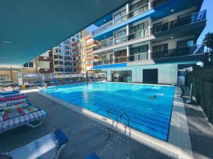 a large swimming pool in front of a building at Traumhaftes Apartment mit Privatstrand, Sea View, Pool, Sauna, Gym, Playground in erster Reihe, Alanya-Mahmutlar in Alanya