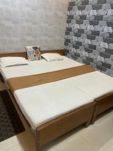 duas camas num quarto com uma parede em Suraj Bhawan em Gaya
