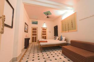1 dormitorio con 1 cama y 1 sofá en una habitación en Hotel Renuka, en Jaisalmer