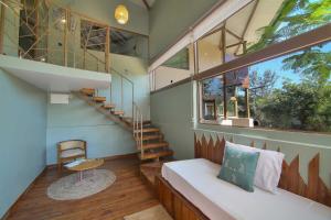 Zimmer mit einem Bett, einer Treppe und einem Fenster in der Unterkunft Tadoba Jungle Camp in Mohurli