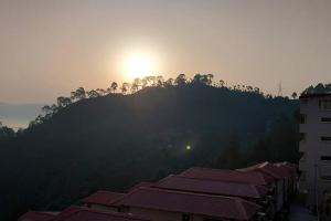 a view of the sun setting over a mountain at Nilay himalayan homestay in Rānīkhet