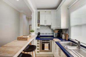una cocina con armarios blancos y encimeras azules en El Mirador de Viana, en La Laguna