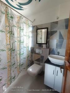 y baño con aseo blanco y lavamanos. en Nilay himalayan homestay, en Rānīkhet