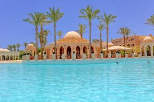 - une piscine en face d'un complexe avec des palmiers dans l'établissement Makadi Palace - Couples and Families Only, à Hurghada