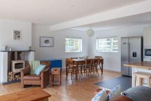 een keuken en een woonkamer met een tafel en stoelen bij Modern Beach House overlooking the Sea in Bigbury