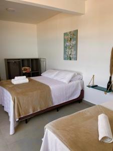 a bedroom with two beds and a picture on the wall at Pousada Hoffmann in Florianópolis