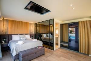 a bedroom with a bed and a tv on the wall at Daedalus Luxury Home - Seaview & Heated Pool in Kontokali