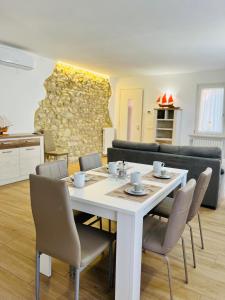 uma sala de jantar com uma mesa branca e cadeiras em Casa Biba em Torri del Benaco