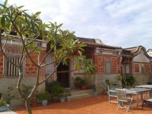 una vecchia casa con un tavolo e delle sedie di fronte di PianoPiano B&B a Jincheng