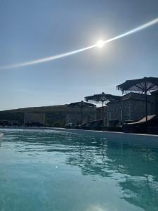 - une piscine d'eau bleue avec des parasols dans l'établissement Ktima Papadopoulou, à Krionérion